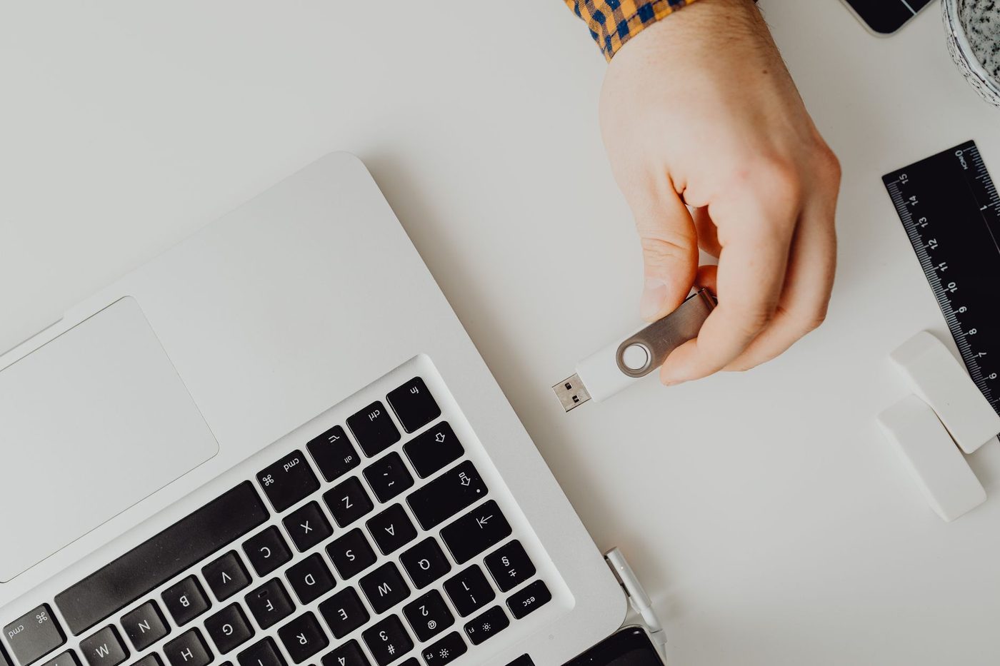 Mano a punto de conectar una memoria USB a un computador portátil